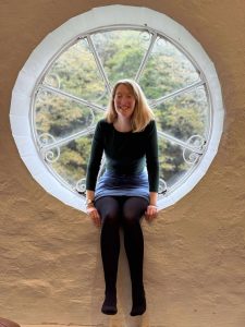 Lucy smiling sitting in a window