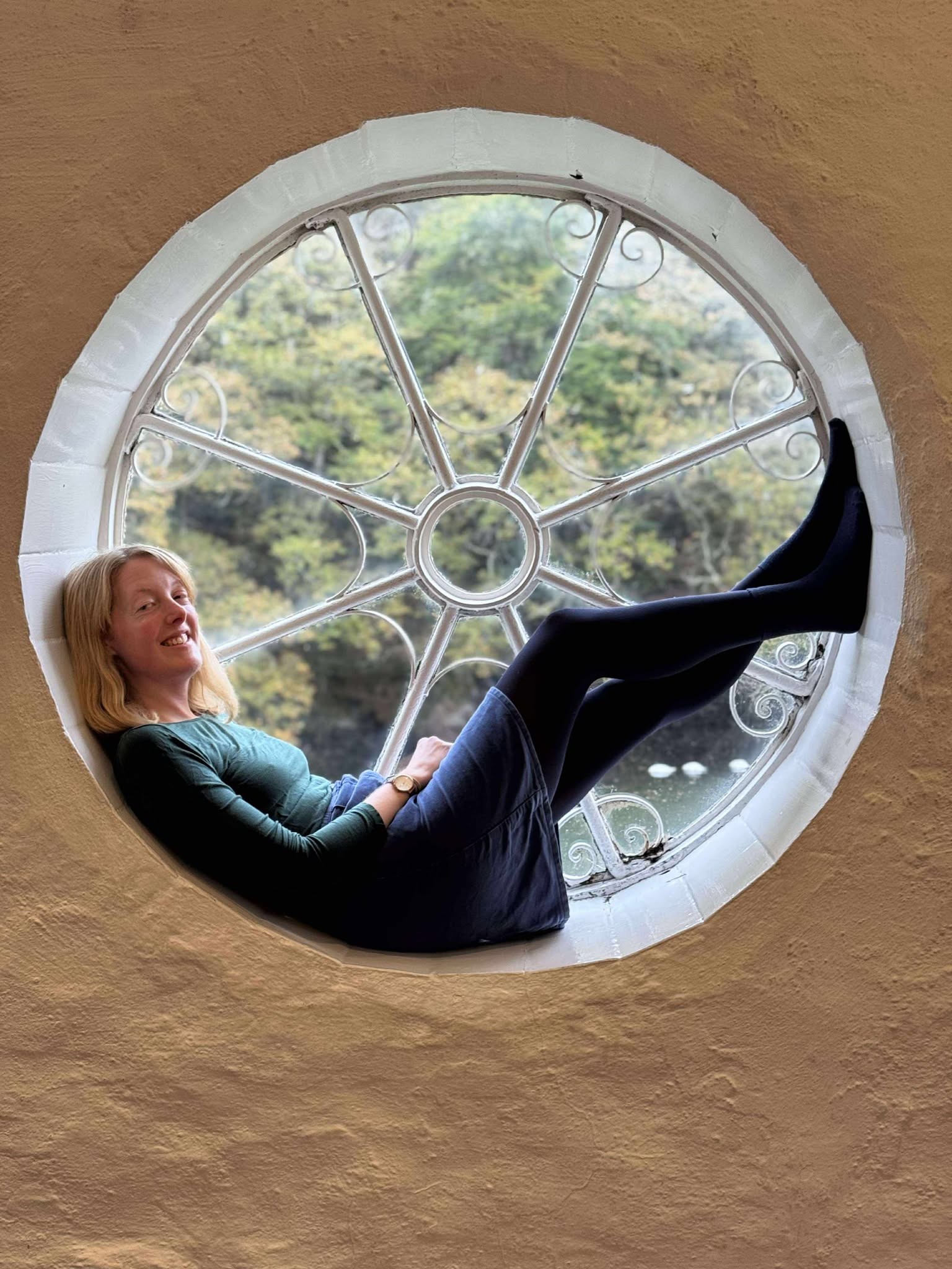 Lucy smiling, sitting in a window
