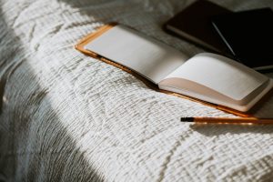 a journal on a bed with a pen