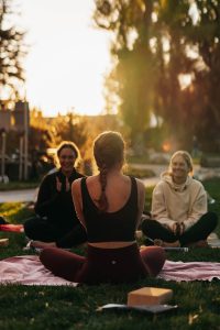 three women sitting in nature surrounded by trees